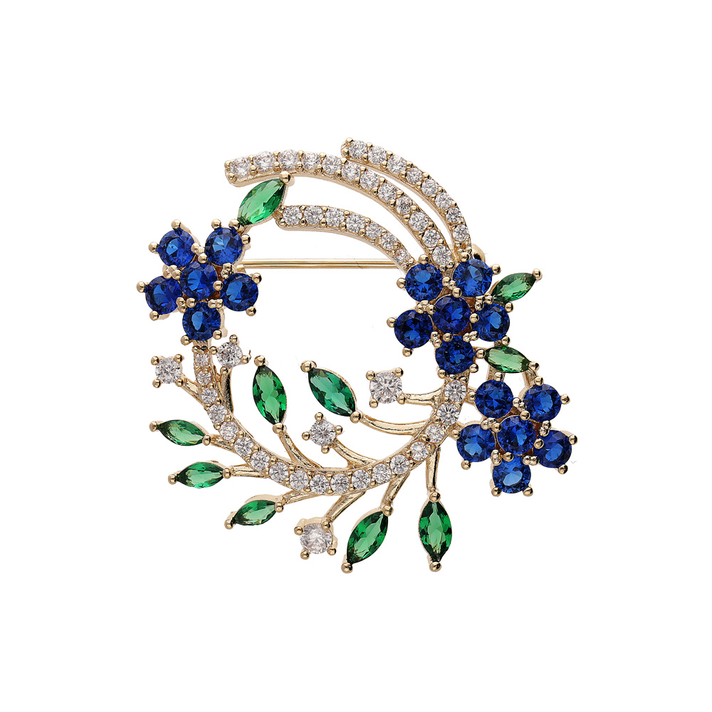 Broche en plaqué or motif feuillage avec oxydes blancs bleus et verts Broche en plaqué or motif feuillage avec oxydes blancs bleus et verts